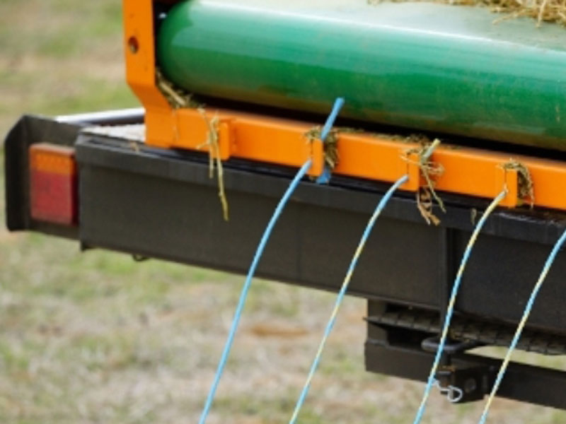 String retention slots holding bale strings on the machine